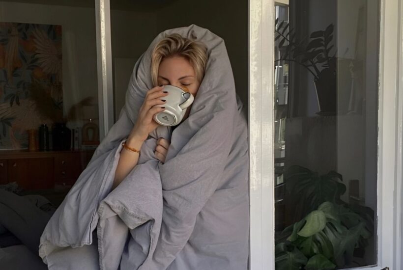 Mujer sonriente retomando su rutina saludable tras las vacaciones, acompañada de productos veganos y antioxidantes ProAge by LFL para mejorar digestión, energía y cuidado de la piel.